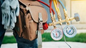 hvac technician with hip tool bag and gauge