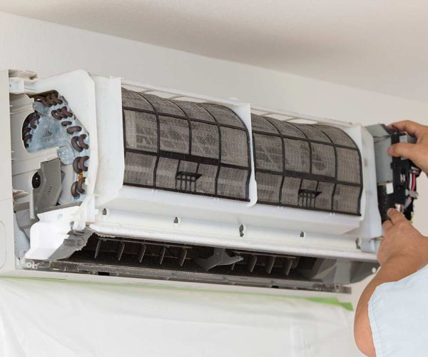 air conditioning company repairing ac unit on wall fort worth tx